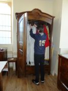 Paul choisit son aube de servant d‘autel dans une armoire réparée